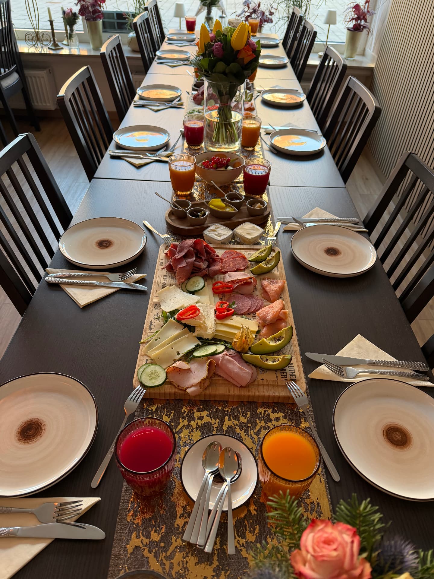 Lang gedeckte Tafel mit Blumendekoration für das Gruppenfrühstück