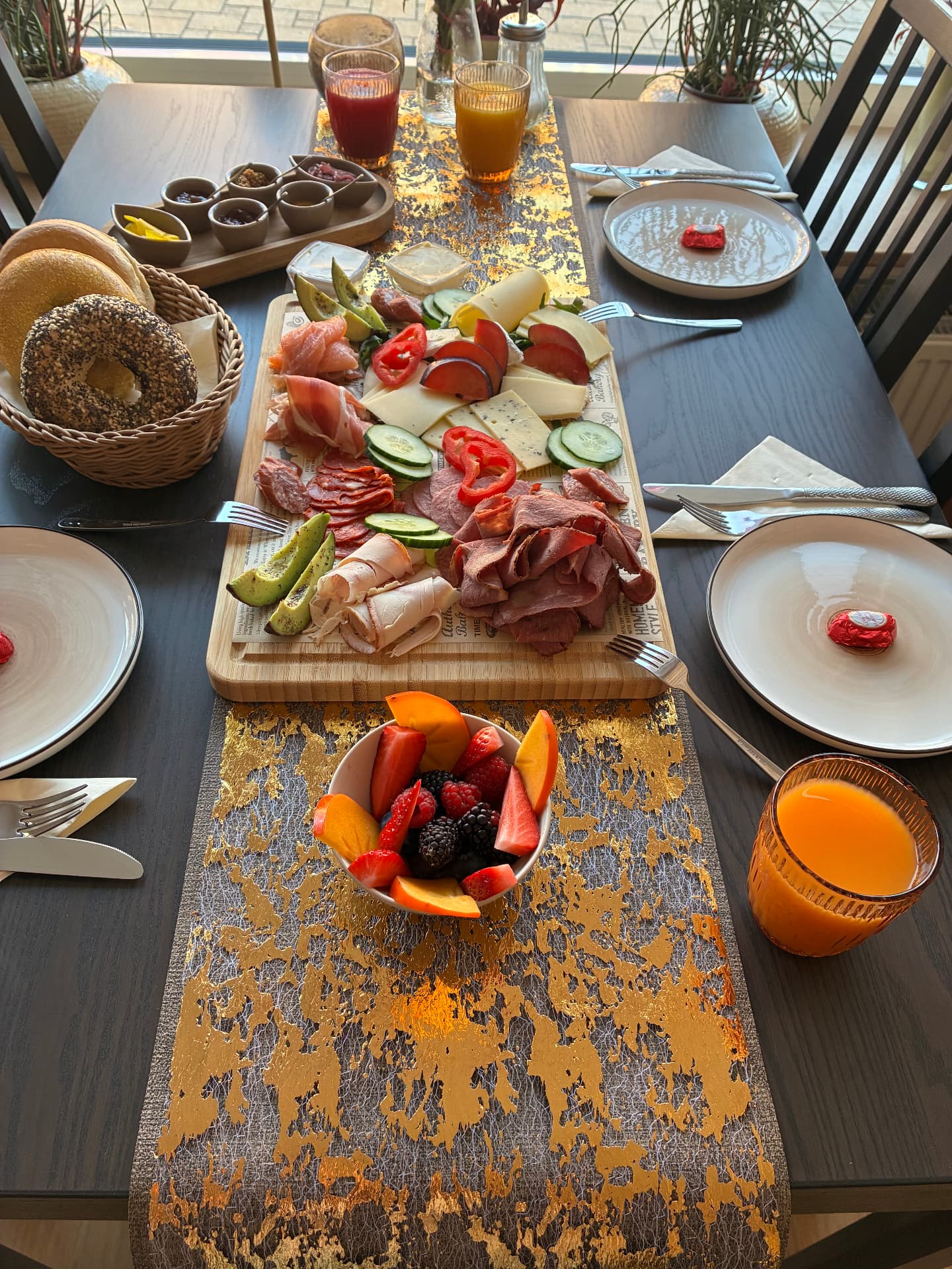 Reichhaltiges Soul-Food-Frühstück mit Obst, Säften und frischen Brötchen